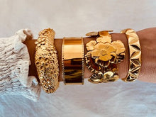 Load image into Gallery viewer, Make a bold statement with this designer 18K gold-plated bangle, featuring a stunning textured flower design. Crafted from high-quality stainless steel for lasting shine, this eye-catching piece exudes elegance and charm. Perfect for stacking or wearing solo, it’s a statement accessory and a beautiful gift for any special occasion!
