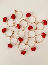 Load image into Gallery viewer, These handcrafted stainless steel earrings showcase a distinctive, irregular hollow circle that hangs gracefully above a vibrant acrylic heart, available in bold red or soft white. The heart dangles elegantly below the circle, creating a playful yet modern contrast that adds a touch of color and movement to any look. Lightweight, durable, and full of personality, these earrings combine geometric precision with artistic flair, making them the perfect accessory to elevate your style for any occasion.