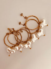 Load image into Gallery viewer, These handcrafted stainless steel earrings showcase a distinctive, irregular hollow circle that hangs gracefully above a vibrant acrylic heart, available in bold red or soft white. The heart dangles elegantly below the circle, creating a playful yet modern contrast that adds a touch of color and movement to any look. Lightweight, durable, and full of personality, these earrings combine geometric precision with artistic flair, making them the perfect accessory to elevate your style for any occasion.