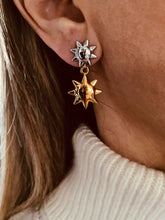 Load image into Gallery viewer, Brighten your look with these fashionable sun pendant stud earrings, designed to add a radiant touch to any outfit. Crafted from durable stainless steel with a polished 18K gold-color plated finish, they feature a sleek sun-inspired design that blends modern style with timeless charm. Lightweight and versatile, these earrings are perfect for everyday wear or as a thoughtful gift for women who love elegant, fashion-forward jewelry.