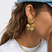 Load image into Gallery viewer, Add a subtle romantic touch to your everyday look with these textured heart drop earrings, designed in a clean and minimalist style. Crafted from durable stainless steel with an 18k gold color plated finish, they offer a refined texture that catches the light beautifully. Hypoallergenic and comfortable for daily wear, these earrings are perfect for women who love modern, understated jewelry with a timeless charm.
