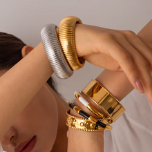 Load image into Gallery viewer, Sleek, modern, and effortlessly stylish, this wide-face open bangle is a must-have accessory for any jewelry collection. Crafted from high-quality stainless steel, it’s waterproof, durable, and designed for all-day comfort. With its smooth, minimalist design, this bracelet adds a touch of elegance to any outfit—perfect for everyday wear or as a thoughtful gift!
